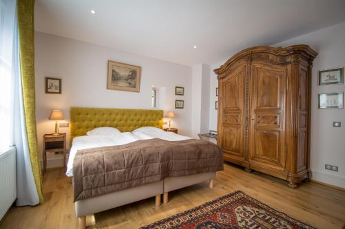 Un dormitorio con una cama grande y un gran armario de madera. en Gite **** Le Meyerhof, en Rorschwihr