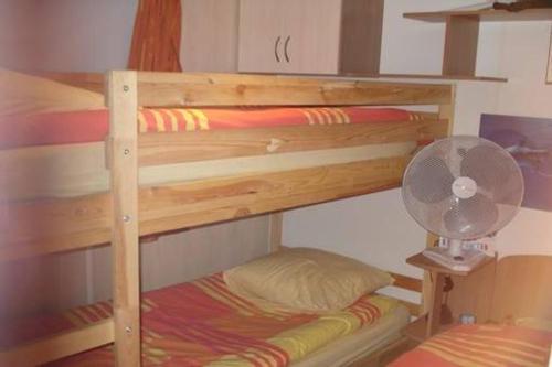 - un lit superposé en bois avec un ventilateur et un oreiller dans l'établissement Mobilhome sur camping le kontiki **** ramatuelle, à Saint-Tropez