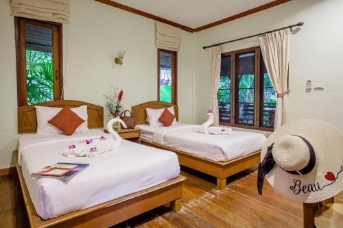 two beds in a room with two swans on them at The Vatika Resort and Spa in Ao Nang Beach