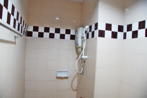 a bathroom with a shower with black and white tiles at Mana Residence in Hat Yai