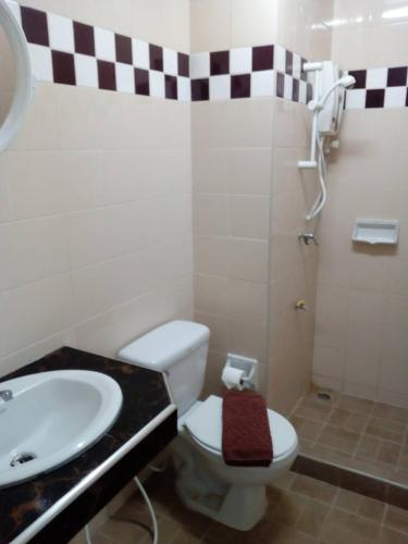 a bathroom with a white toilet and a sink at Mana Residence in Hat Yai