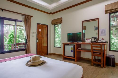 a hat is sitting on a bed in a bedroom at The Vatika Resort and Spa in Ao Nang Beach