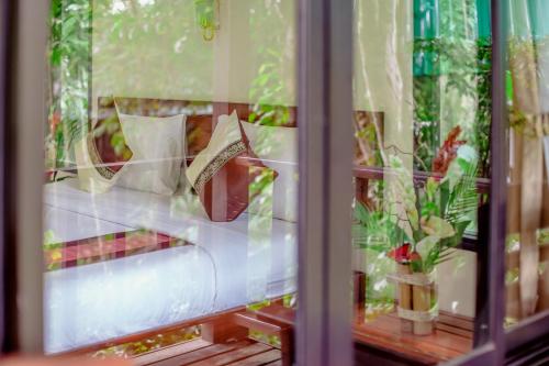 a reflection of a couch with pillows in a window at The Vatika Resort and Spa in Ao Nang Beach