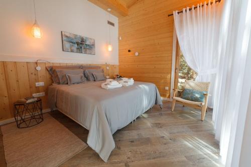 a bedroom with a bed and a chair and a window at Rinoterra Minho in Caminha