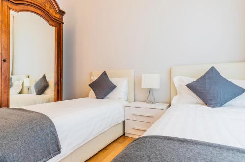 two beds in a bedroom with a mirror at Milan Retreats in Milan