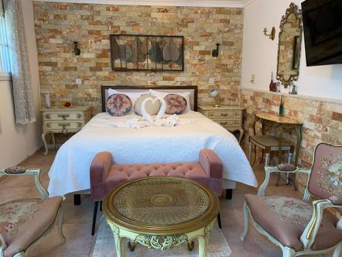 a bedroom with a bed with a table and chairs at farmer’s suite room in Bat Shelomo