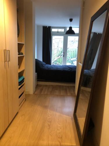 a hallway with a mirror and a bed in a room at house with garden, 10 min from city centre in Amsterdam