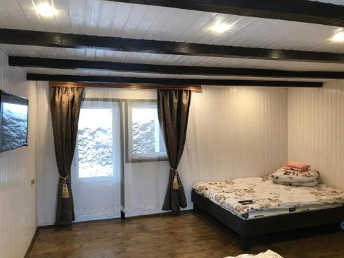 1 dormitorio con 1 cama y 2 ventanas en Cottage v Gorakh, en Izky
