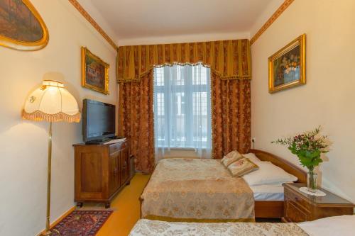 1 dormitorio con 1 cama, TV y ventana en Metropolitan Apartments, en Cracovia