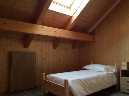 a bedroom with a bed and a skylight at Da Alsido in Camporosso in Valcanale