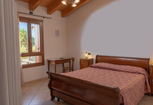 Schlafzimmer mit einem Bett und einem Fenster in der Unterkunft Agriturismo Paradiso in Sarego