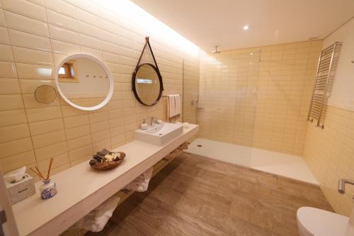 a bathroom with a sink and a tub and a mirror at Rinoterra Minho in Caminha