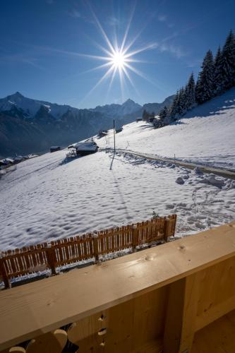 a snow covered slope with the sun in the sky at Klette in Hippach