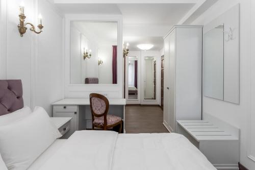 a bedroom with two beds and a desk and a mirror at Lahovary Palace Hotel in Bucharest