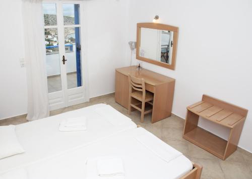 a bedroom with a bed and a desk and a mirror at Aiolos Iraklia in Iraklia