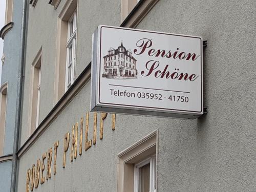 a sign for a restaurant on the side of a building at Pension Schöne in Großröhrsdorf