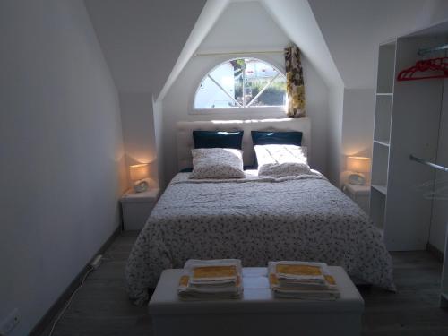 a bedroom with a large bed with a window at Chez Mado in Deauville