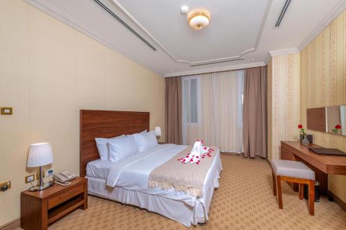 a hotel room with a bed and a desk at Al Diyafa Furnished Suites in Doha