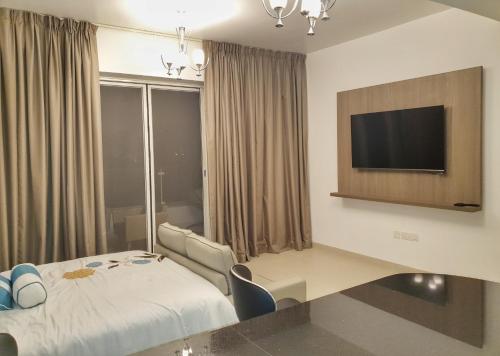 a hotel room with a bed and a flat screen tv at Sifah Resort Studio in As Sīfah