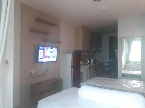 a small kitchen with a small television on a wall at ENVIRO Studio in Cikarang