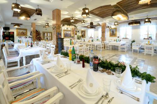 a dining room with white tables and white chairs at Srpsko Andrejevo Selo in Belgrade