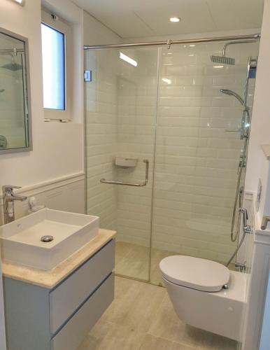 a bathroom with a shower and a toilet and a sink at Sifah Resort Studio in As Sīfah