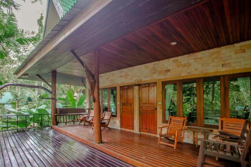 a porch of a house with chairs and windows at The Vatika Resort and Spa in Ao Nang Beach