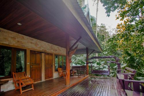 a house with a wooden deck with chairs on it at The Vatika Resort and Spa in Ao Nang Beach
