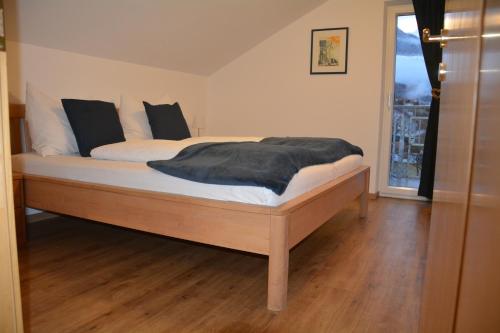 a bed with black and white pillows on it at Apart Pitztalurlaub in Wenns