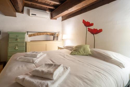 a bedroom with a white bed with towels on it at Lambertesca Loft in Florence