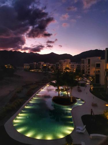 a view of a swimming pool at night at Sifah Resort Studio in As Sīfah