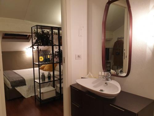 uma casa de banho com um lavatório e um espelho ao lado de uma cama em Vico - Corso Como 11 em Milão
