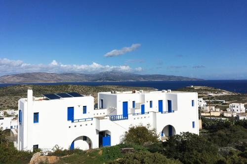 a view of a white building with the ocean in the background at Aiolos Iraklia in Iraklia