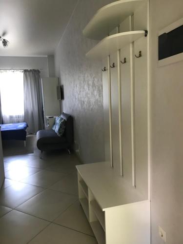 a kitchen with white cabinets and a living room at Дом in Kyiv