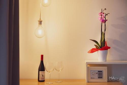 a bottle of wine and two wine glasses on a table at Marla's boutique rooms in Noto