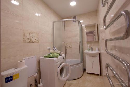 een badkamer met een douche, een toilet en een wastafel bij Lukšio Apartment in Šiauliai