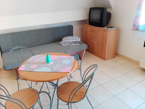 a room with a table and chairs and a tv at Dom štúdia Petra in Štúrovo