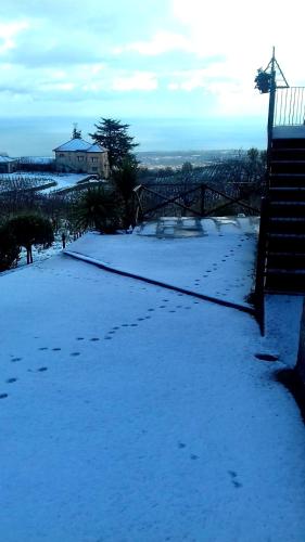 a snow covered hill with a house in the distance at Villa Etna Masi' in Milo