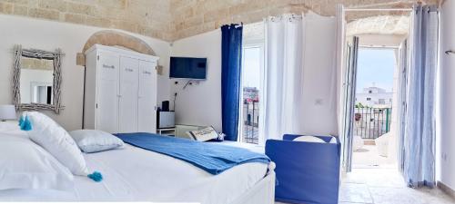 - une chambre avec un lit et une grande fenêtre dans l'établissement POSEA - Polignano Sea Suites, à Polignano a Mare