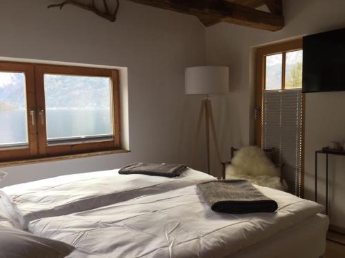 een slaapkamer met een bed met twee handdoeken erop bij Bootshaus am Hallstätter See in Hallstatt