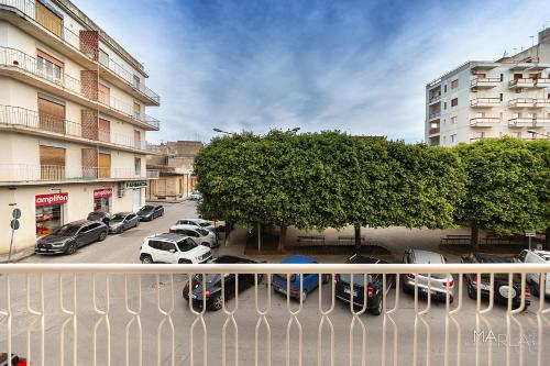 a balcony with cars parked in a parking lot at Marla's boutique rooms in Noto
