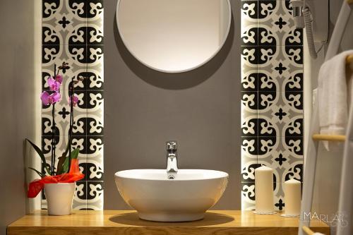 a bathroom with a white sink and a mirror at Marla's boutique rooms in Noto