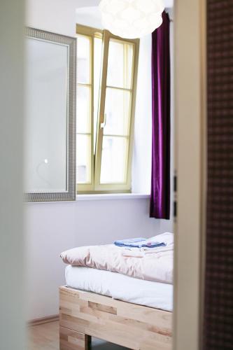 a mirror in a room with a bed under a window at Hotel Blaue Blume in Freiberg