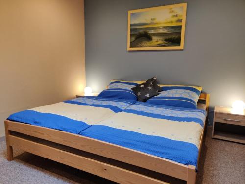 Schlafzimmer mit einem Bett mit blauer und weißer Bettwäsche in der Unterkunft Feriendomizil im Lieper Winkel in Liepe