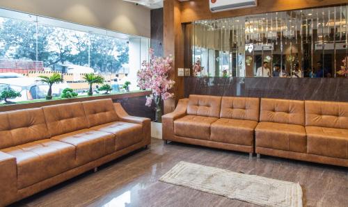 a lobby with two brown leather couches in a store at Hotel Hometown Near US Embassy BKC in Mumbai
