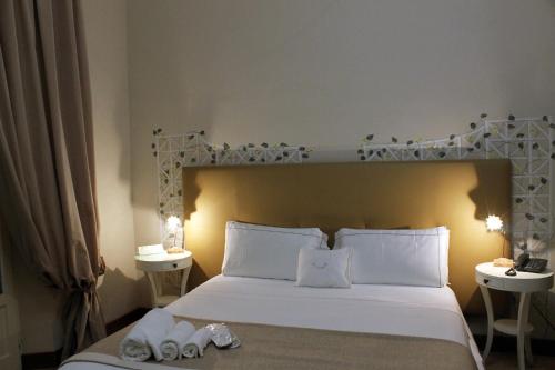 a bedroom with a large white bed with two tables at B&B Milu' in Crotone