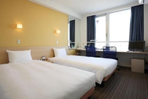 Postel nebo postele na pokoji v ubytování Smile Hotel Sendai Tagajyo