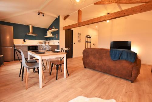 a living room with a couch and a table at LE TOIT D'AUVERS - T2- 2e étage in Auvers-sur-Oise