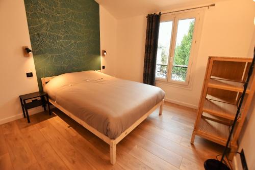 1 dormitorio con cama y ventana en LE TOIT D'AUVERS - T2- 2e étage, en Auvers-sur-Oise