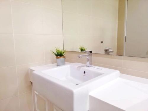 a bathroom with a white sink and a mirror at Happy Holiday in Shah Alam